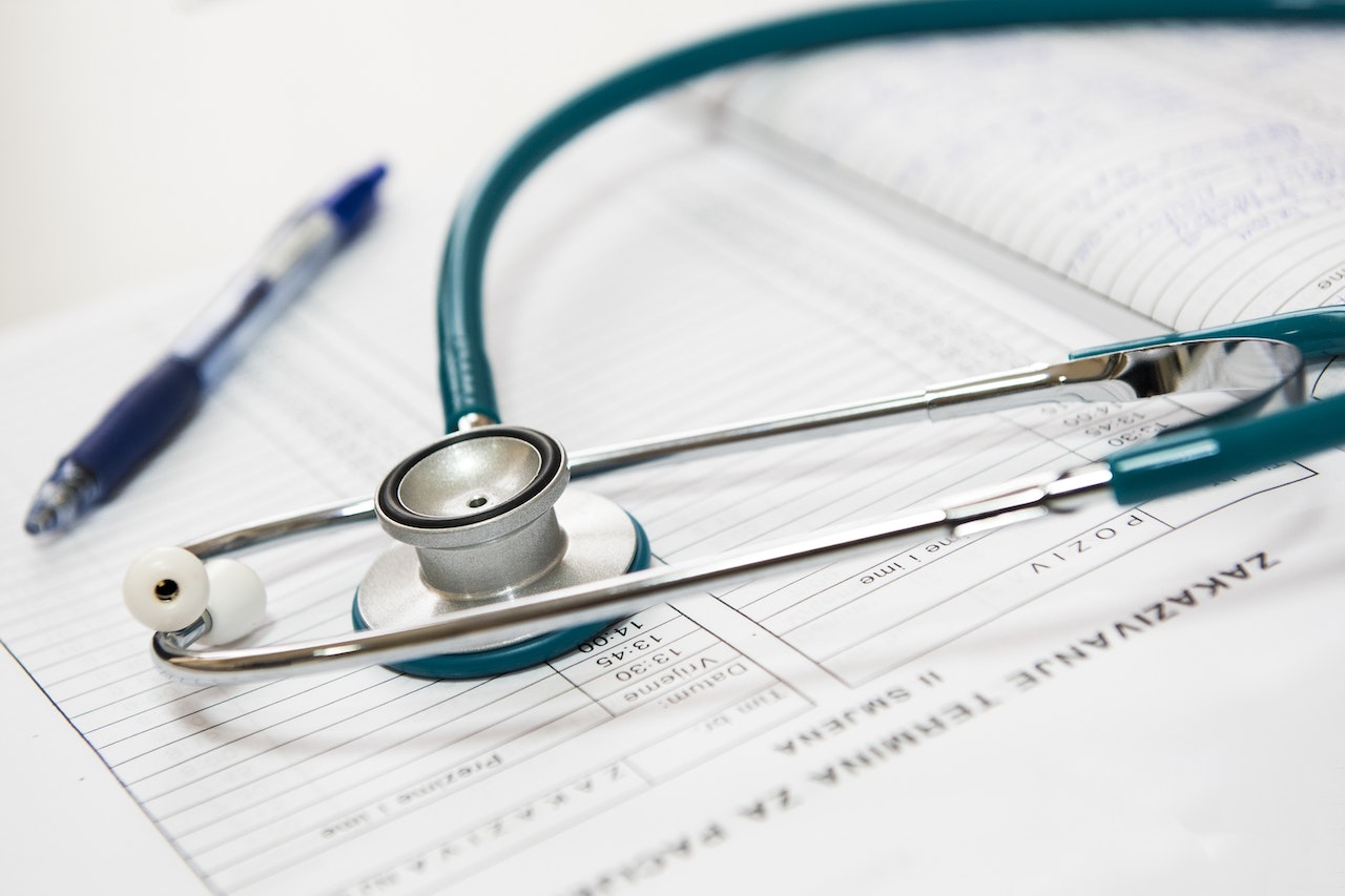 A close-up view of a stethoscope on some medical files.